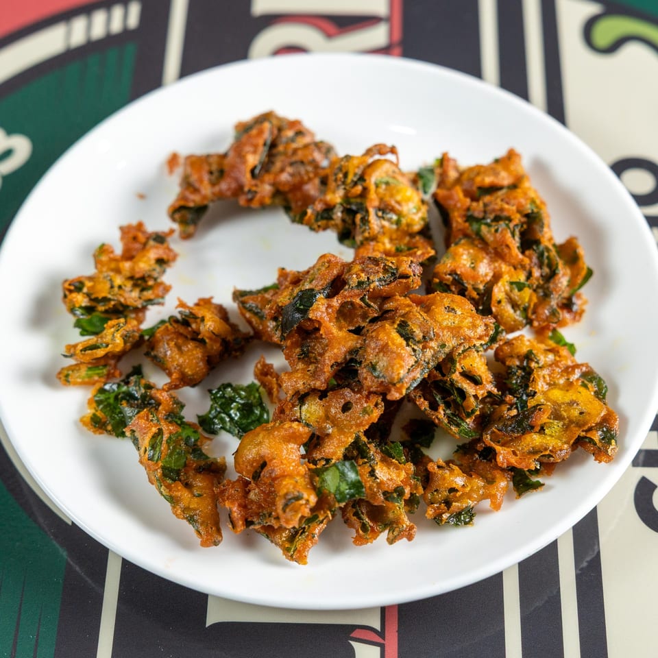 Crispy vegetable fritters on a white plate.