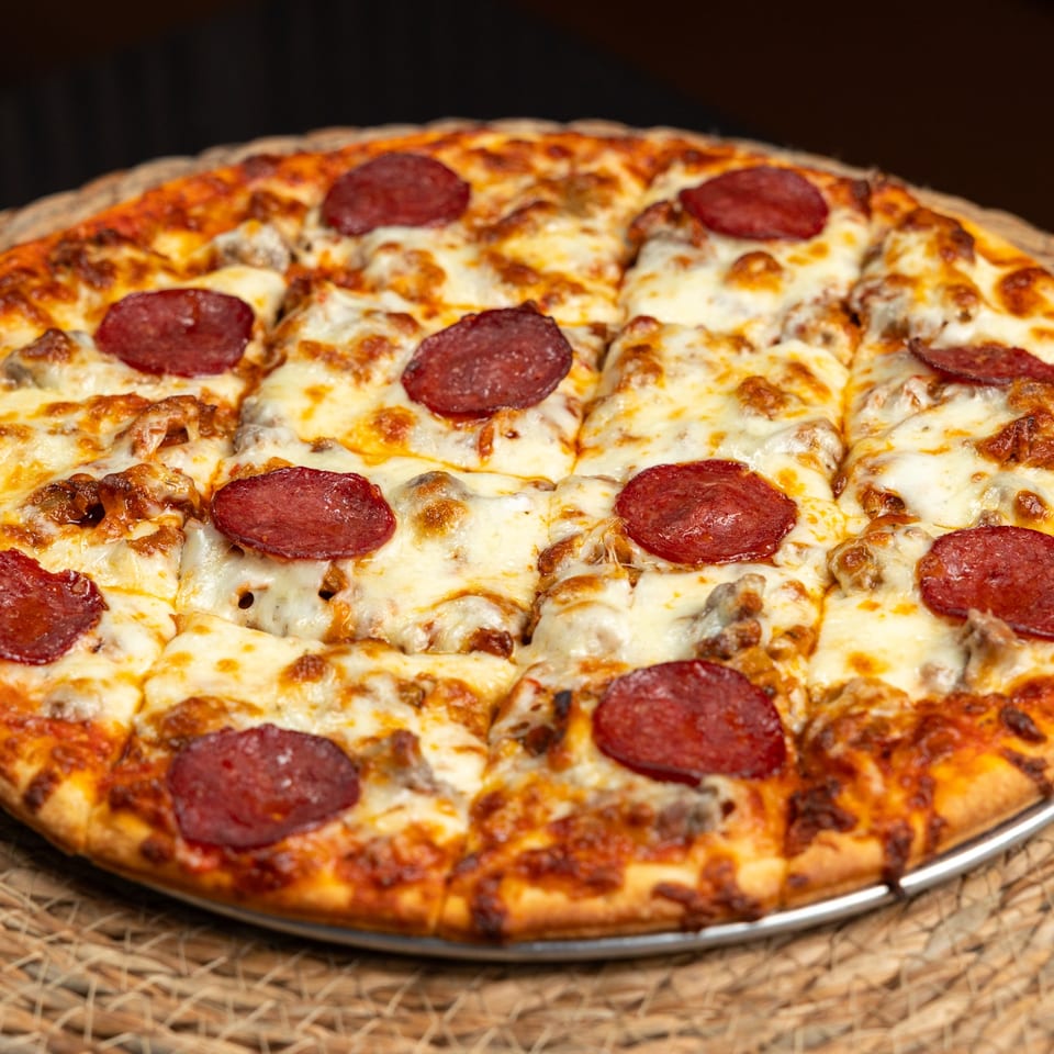Close-up of pizza topped with pepperoni and melted cheese.