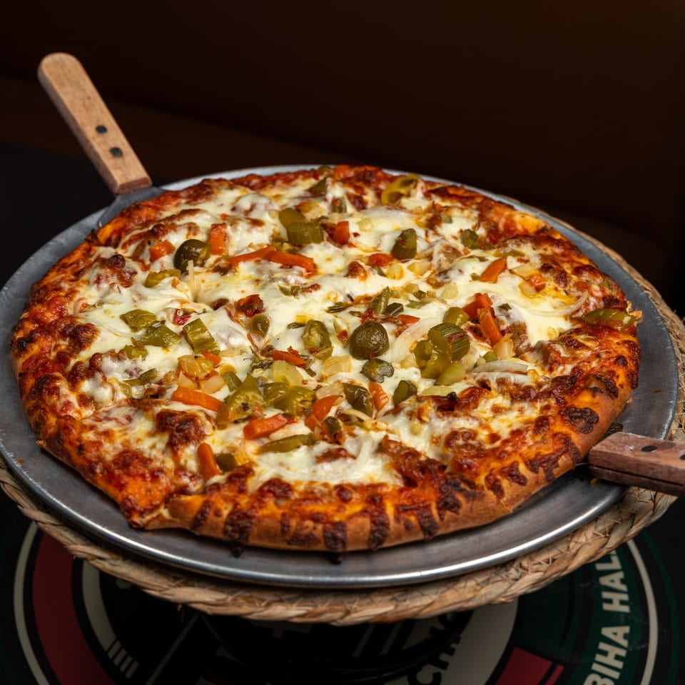 Pizza topped with cheese, onions, and chopped peppers.